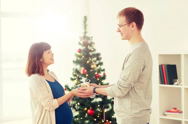 Marito dando regalo di Natale alla moglie incinta — Foto Stock