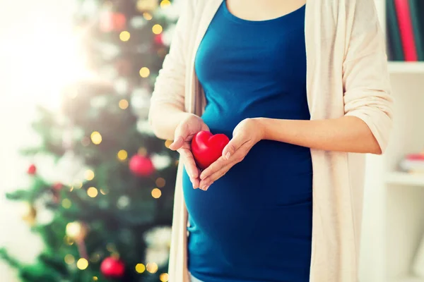 Primo piano di donna incinta con cuore a Natale — Foto Stock