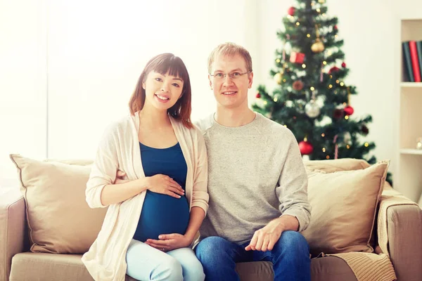 Moglie incinta con marito a casa a Natale — Foto Stock