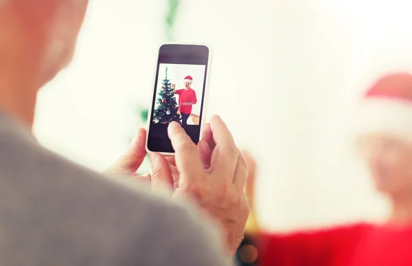 Close up of senior man picturing wife at christmas — Stock Photo, Image