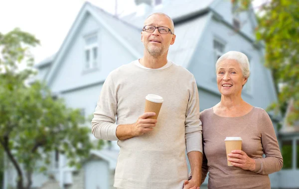 Happy senior couple with coffee over living house — Stock Photo, Image