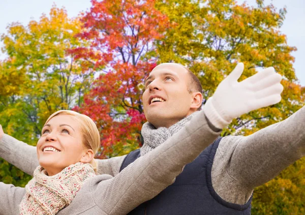 Happy couple spreading hands leaves in autumn park — Stock Photo, Image