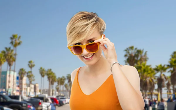 Portrait de jeune femme souriante en lunettes de soleil — Photo