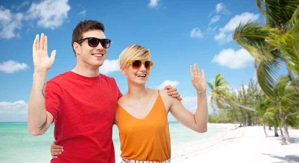 Couple in sunglasses hugging and waving hands — Stock Photo, Image