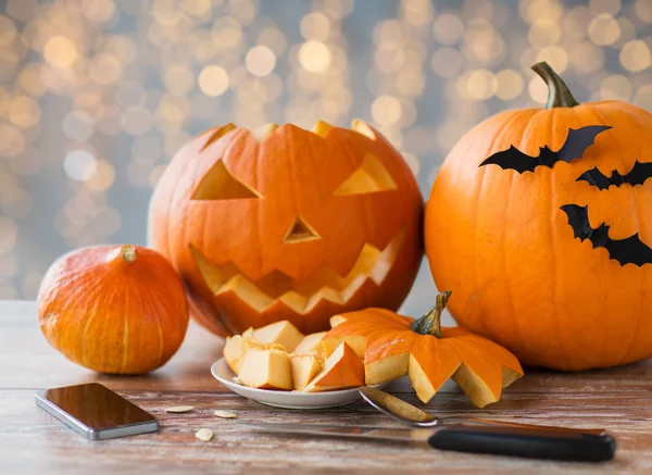 Halloween jack-o-lantern, pompoenen en smartphone — Stockfoto