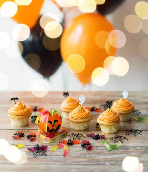 Halloween party decorated cupcakes on wooden table — Stock Photo, Image