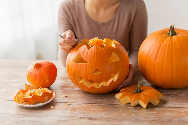 Närbild av kvinna carving halloween pumpa — Stockfoto