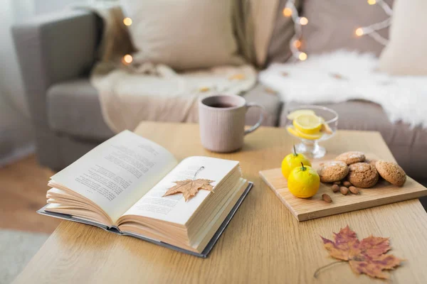 Libro, limón, té y galletas en la mesa en casa — Foto de Stock