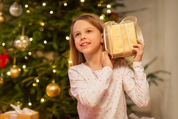 Chica sonriente con regalo de Navidad en casa —  Fotos de Stock