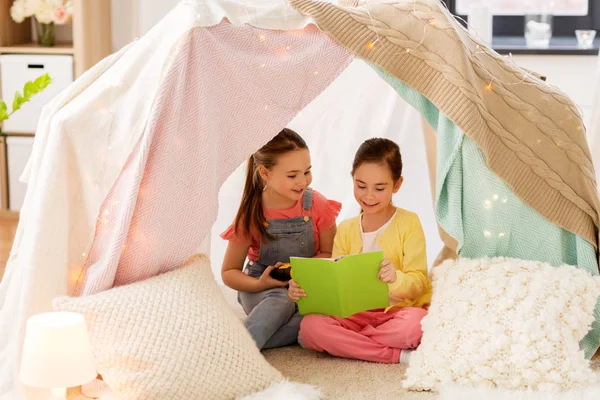 Kleine Mädchen lesen Buch im Kinderzelt zu Hause — Stockfoto