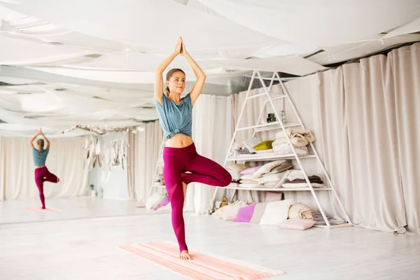 Joven mujer haciendo yoga árbol pose en estudio — Foto de Stock