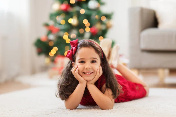 Chica feliz tumbada en el suelo en casa en Navidad —  Fotos de Stock