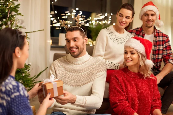 Amigos celebrando o Natal e dando presentes — Fotografia de Stock