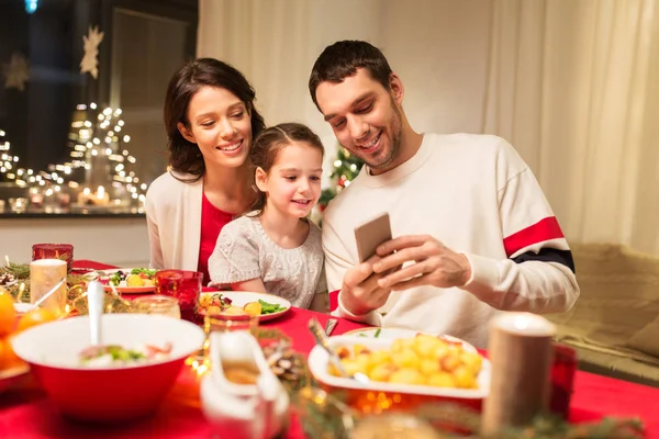 Familie mit Smartphone beim Weihnachtsessen — Stockfoto