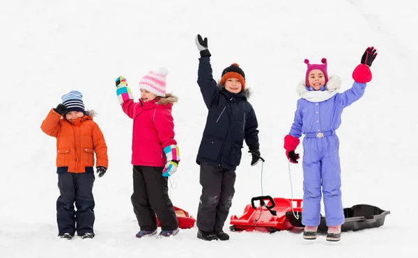 冬に手を振ってそりで幸せな子供たち — ストック写真