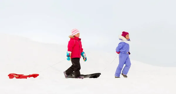 Happy μικρά κορίτσια με τα πόδια το χειμώνα έλκηθρα — Φωτογραφία Αρχείου