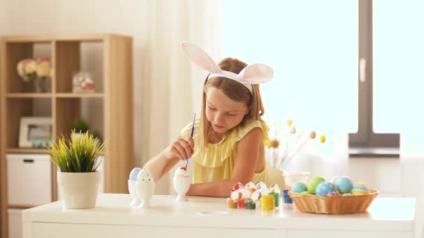 Счастливая девушка раскрашивает яйца в домашних условиях — стоковое видео