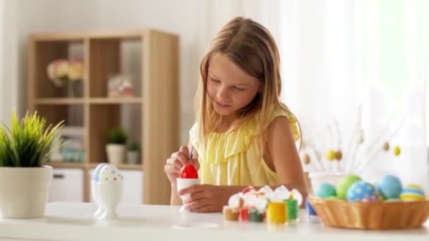 Ευτυχισμένος κορίτσι χρωματισμός αυγά του Πάσχα στο σπίτι — Αρχείο Βίντεο