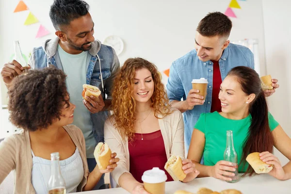 Glückliche Freunde oder Team essen auf Büroparty — Stockfoto