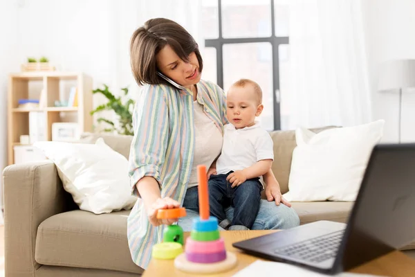 working mother with baby calling on smartphone