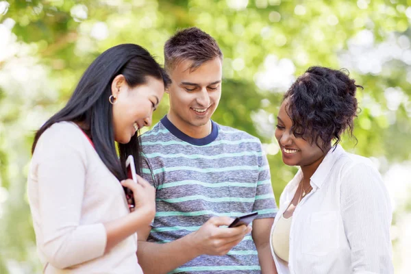 Grupp av glada vänner med smartphone utomhus — Stockfoto