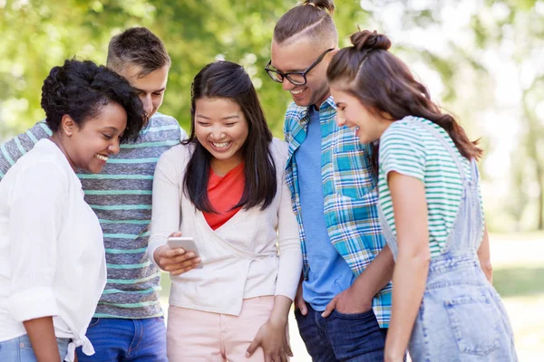 Grupp av glada vänner med smartphone utomhus — Stockfoto