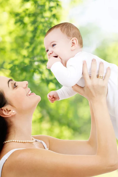 緑の自然な背景の上の赤ちゃんと母親 — ストック写真
