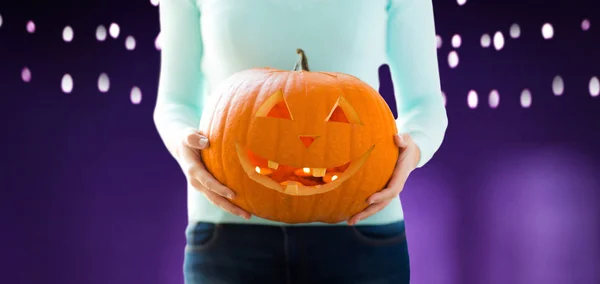 Nahaufnahme einer Frau, die einen Halloween-Kürbis hält — Stockfoto