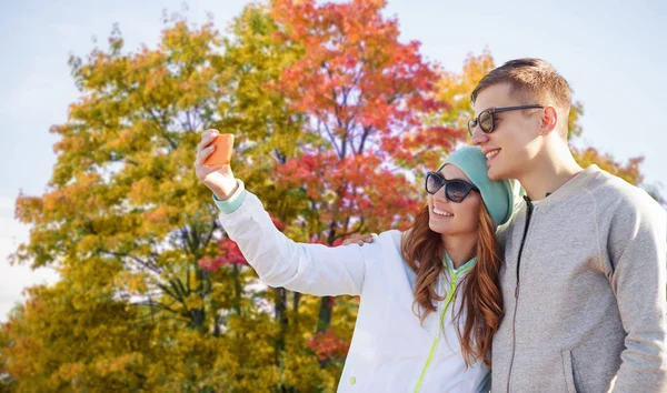 Pár pořizování selfie pomocí smartphone na podzim park — Stock fotografie