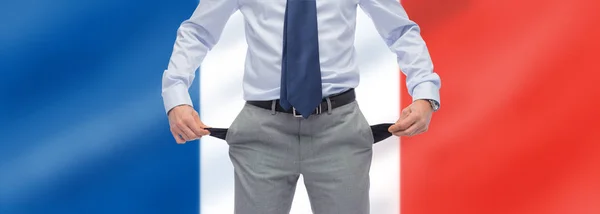 Businessman with empty pockets over flag of france — Stock Photo, Image