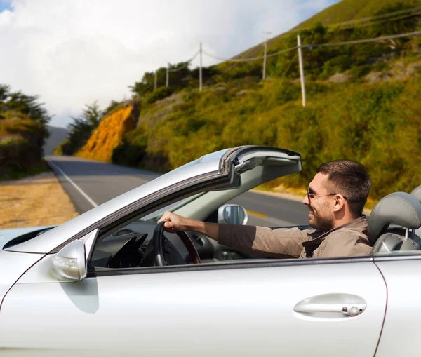 Homem dirigindo carro conversível sobre grandes colinas sur — Fotografia de Stock