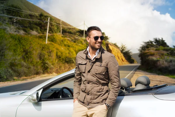 Hombre en coche descapotable sobre grandes colinas sur —  Fotos de Stock