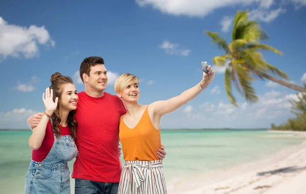 Friends taking selfie by smartphone and hugging — Stock Photo, Image