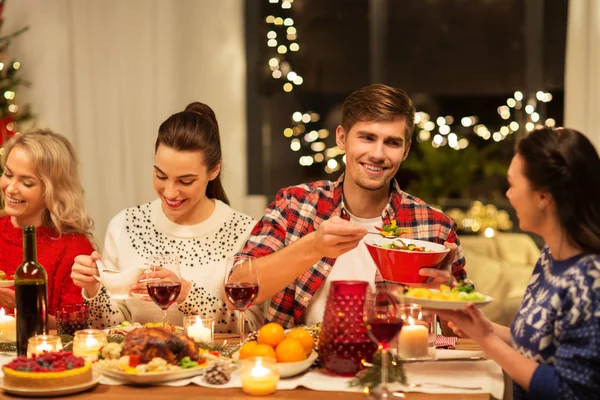 Amigos felices teniendo la cena de Navidad en casa —  Fotos de Stock