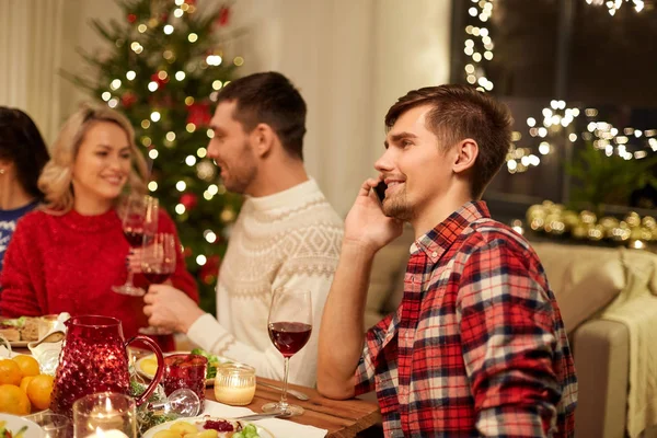 Мужчина звонит на смартфон на рождественский ужин — стоковое фото