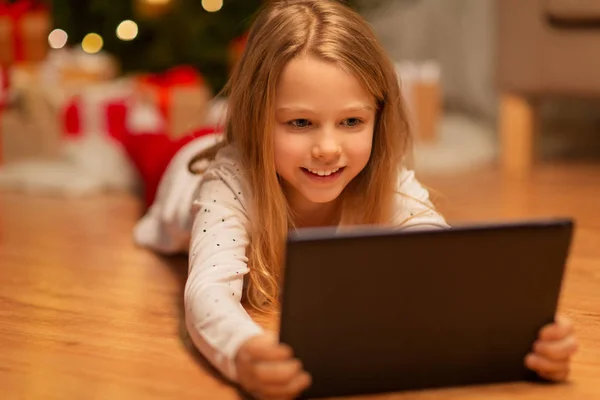 Menina sorridente com tablet pc em casa de Natal — Fotografia de Stock