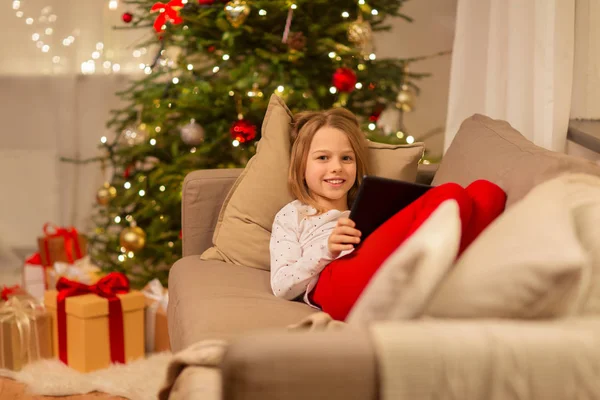 Chica sonriente con la tableta de la PC en casa de Navidad —  Fotos de Stock