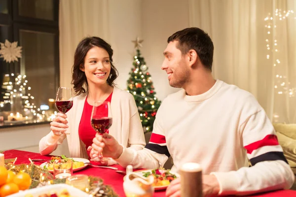 幸せなカップルはクリスマスディナーで赤ワインを飲む — ストック写真