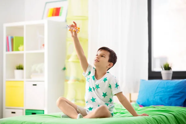 Menino feliz brincando com brinquedo de avião em casa — Fotografia de Stock