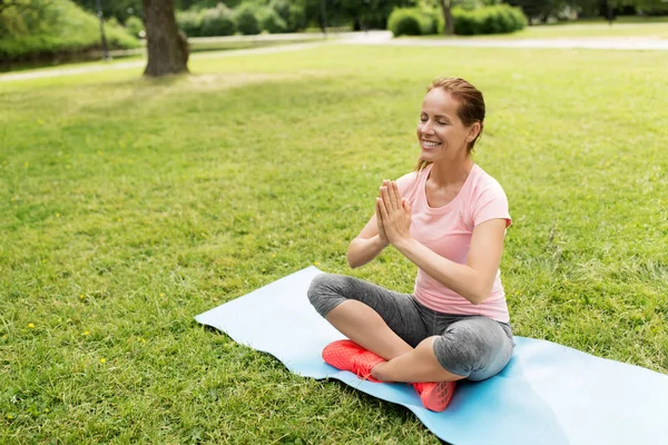 Glückliche Frau meditiert im Sommerpark — Stockfoto