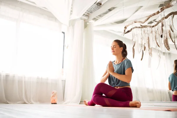 Женщина медитирует в студии йоги — стоковое фото