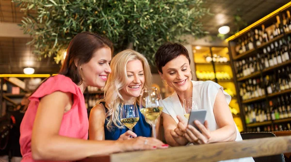 Kobiety z smartphone w winiarni lub restauracji — Zdjęcie stockowe
