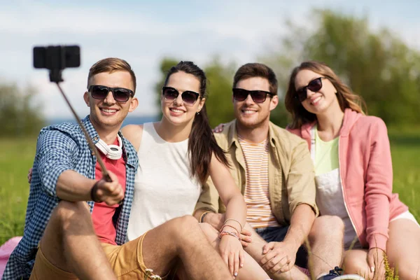 Amigos tomando foto por selfie palo en verano — Foto de Stock