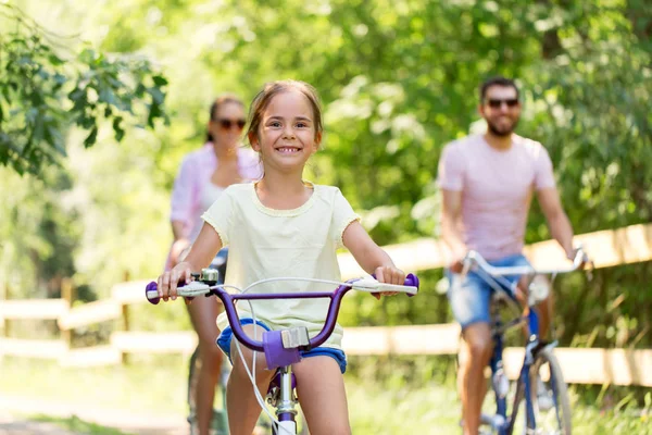 レジャー 人コンセプト 幸せな母 父と幼い娘の夏の公園で自転車に乗って — ストック写真