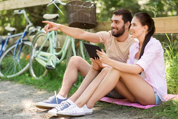 Couple avec tablette PC et vélos au parc d'été — Photo