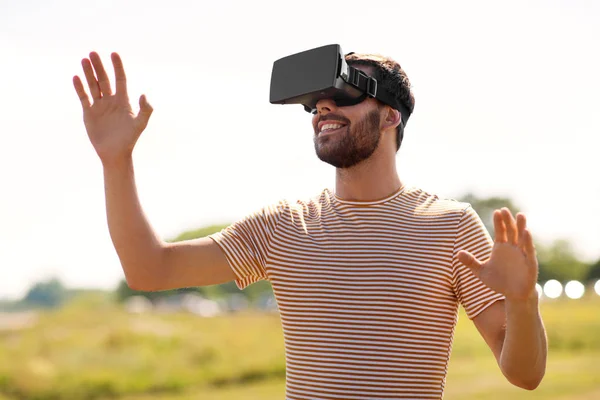 Uomo sorridente in realtà virtuale auricolare all'aperto — Foto Stock