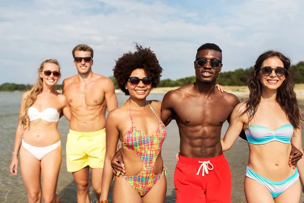 Glada vänner kramas på sommaren stranden — Stockfoto