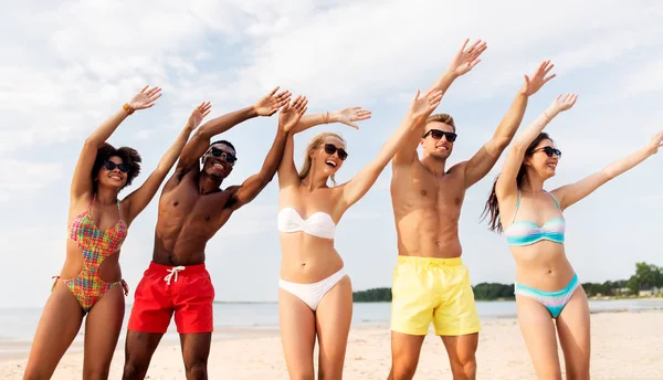 Щасливі друзі розважаються на літньому пляжі Стокова Картинка
