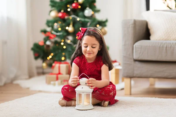 little girl with lantern at home on christmas