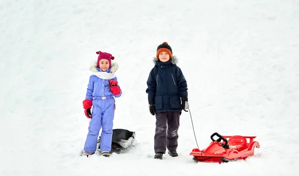 Niños pequeños felices con trineos en invierno —  Fotos de Stock